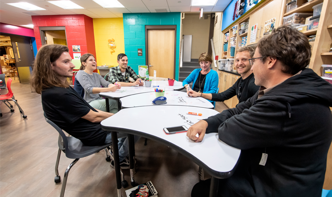 Teachers talking around a table in a classroom