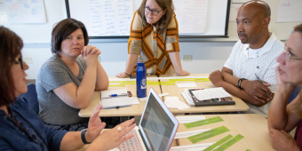 Leaders talking around a table in a school